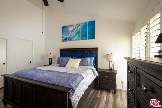a bedroom with a bed and a flat tv screen on dresser