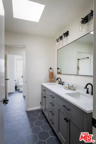 a spacious bathroom with a sink and a mirror