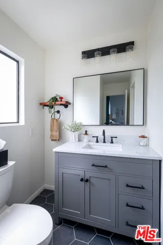 a bathroom with a toilet a sink and mirror