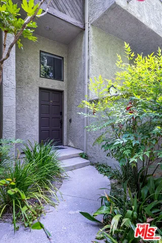 a couple of flower plants in front of door