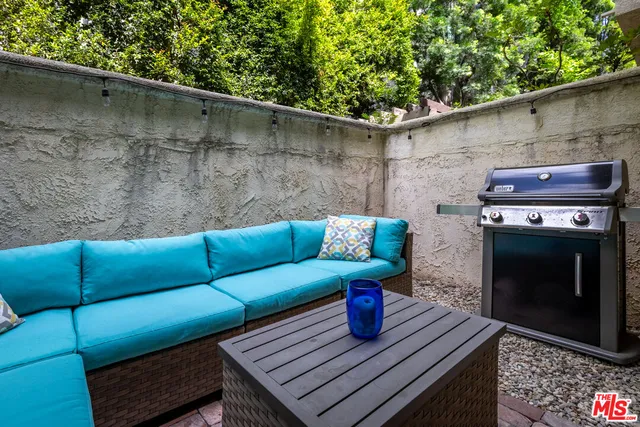 a view of a street with potted plants and large trees