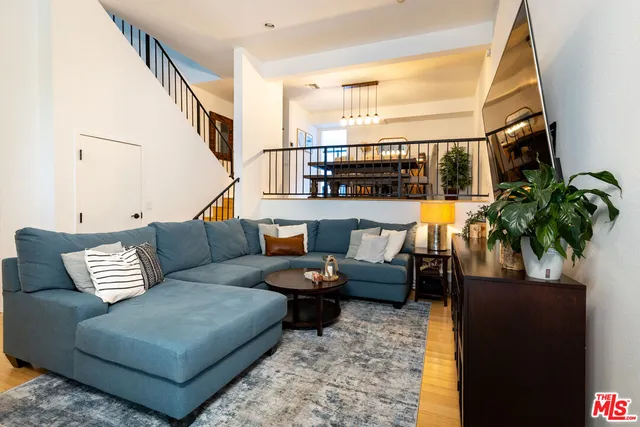 a living room with furniture kitchen view and a large window