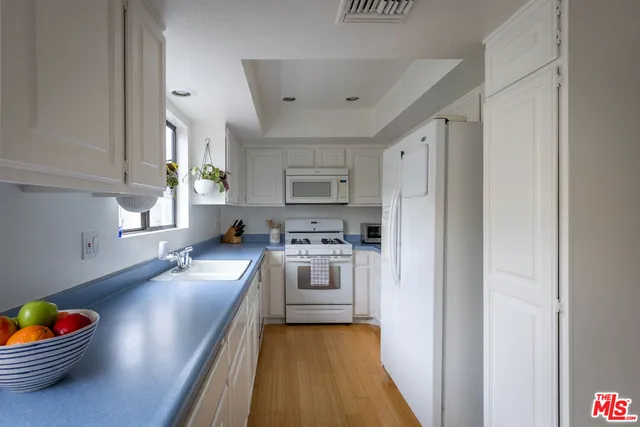 a kitchen with stainless steel appliances granite countertop a refrigerator a sink dishwasher a stove with wooden cabinets