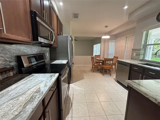 a kitchen with stainless steel appliances granite countertop a sink a stove and a refrigerator