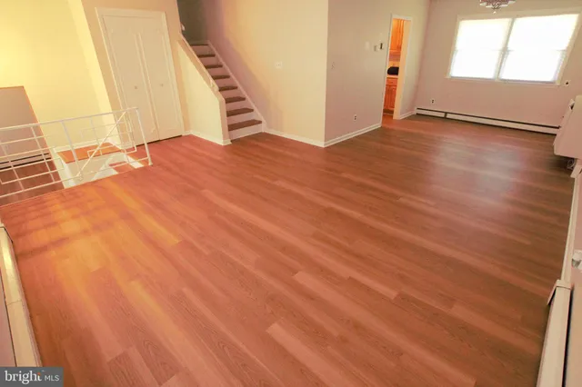 an empty room with wooden floor and stairs