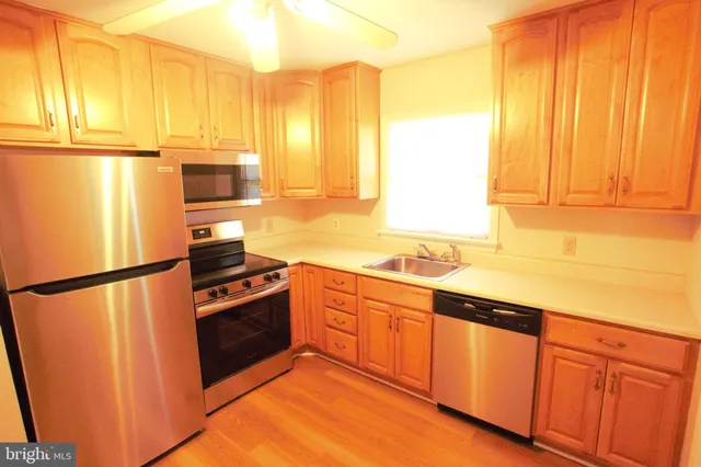 a kitchen with stainless steel appliances a refrigerator sink and cabinets