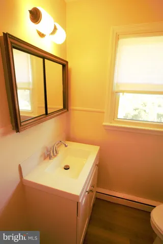 a bathroom with a sink a toilet and a window