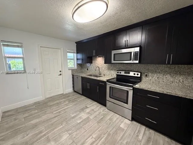 a kitchen with granite countertop stainless steel appliances and wooden cabinets