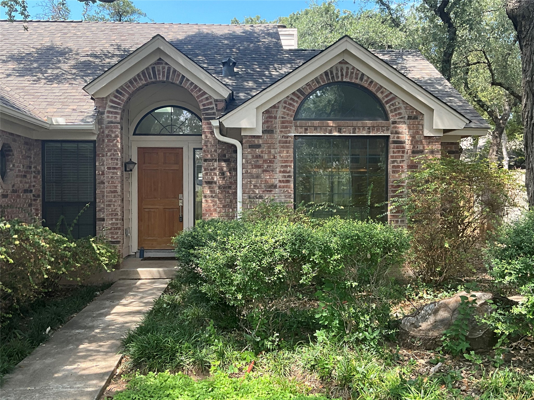 15702 Racine Cove Austin, TX 78717 - Photo 1 of 27 A classic brick exterior with inviting arched windows and mature landscaping.