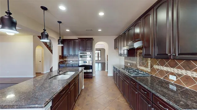 a kitchen with granite countertop stainless steel appliances and wooden cabinets