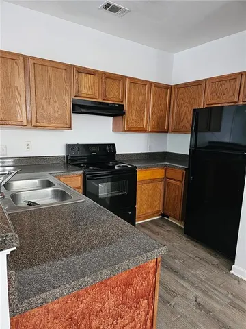 a kitchen with granite countertop wooden cabinets and a stove top oven