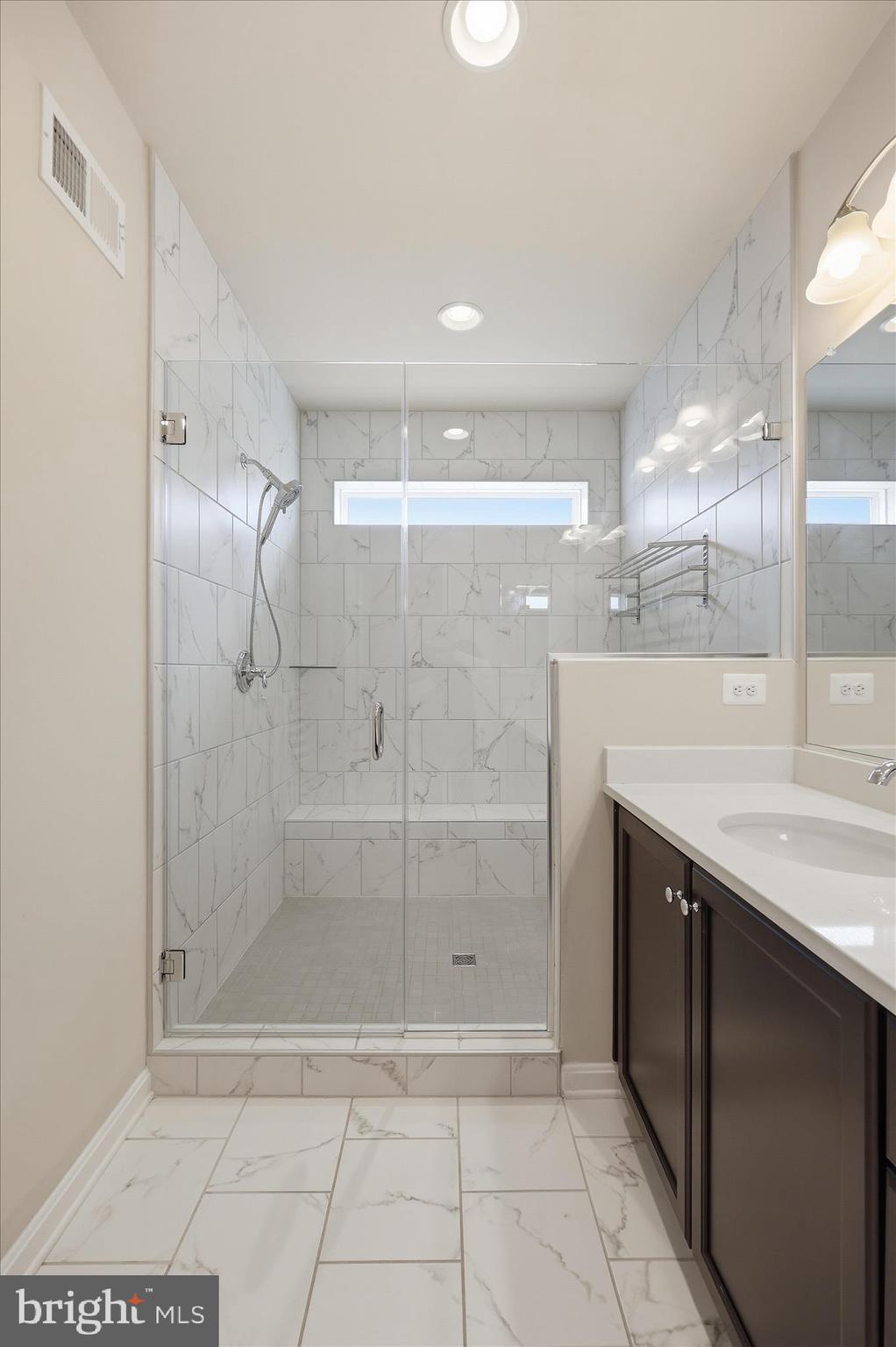 1090 Holden Road Frederick, MD 21701 - Photo 22 of 60 a bathroom with a granite countertop shower a mirror and a shower