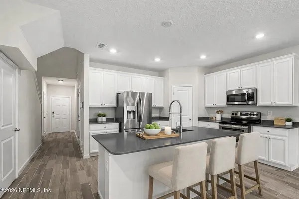 a kitchen with stainless steel appliances a sink stove refrigerator and cabinets