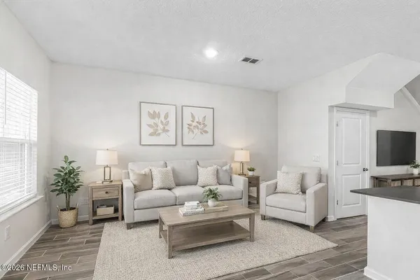 a living room with furniture a flat screen tv and a large window