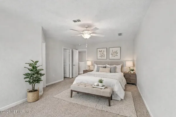 a bedroom with a large bed and a potted plant