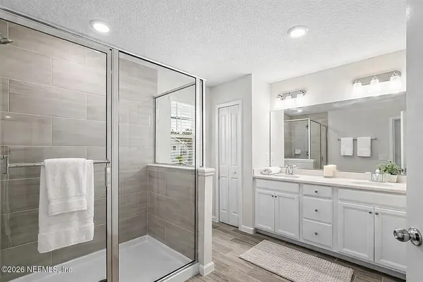 a spacious bathroom with a shower sink and mirror