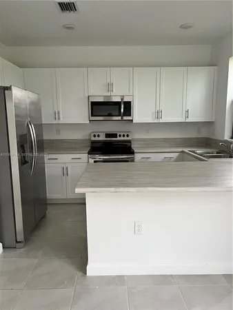 a kitchen with granite countertop a stove sink and cabinets