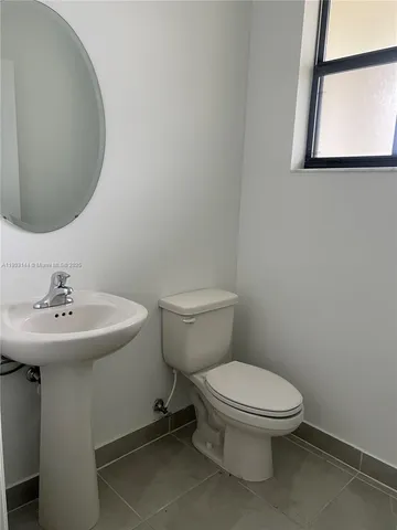a bathroom with a toilet a sink and a mirror