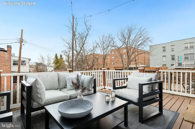 a roof deck with couches and wooden floor