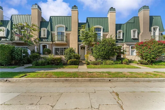 a front view of a house with a garden and plants
