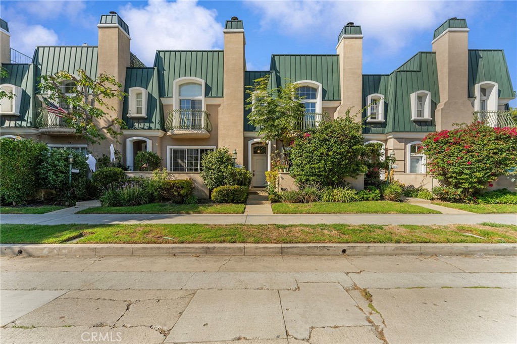 a front view of a house with a garden and plants