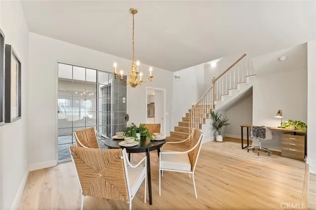 a dining room with furniture a chandelier and wooden floor