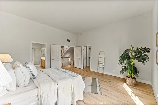 a bedroom with a large bed and a potted plant