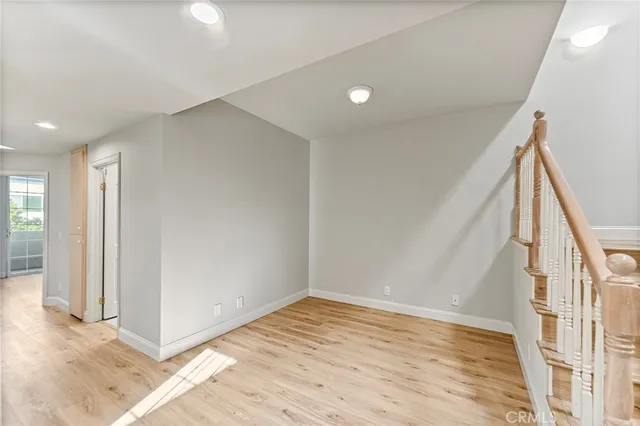 a view of an empty room with wooden floor and entryway