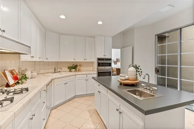 a kitchen with sink stove and cabinets