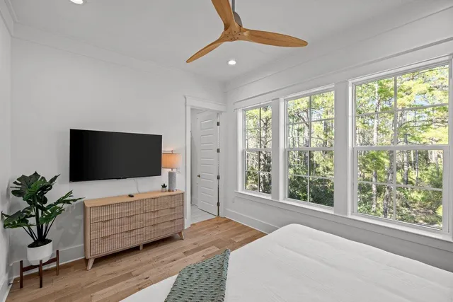 a living room with furniture a flat screen tv and large window