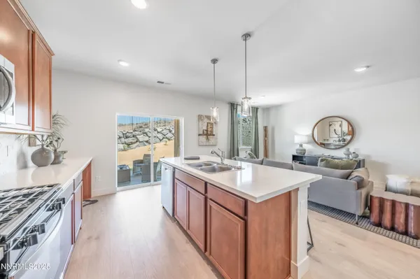 a kitchen with stainless steel appliances granite countertop a stove top oven a refrigerator a sink and dishwasher a oven with wooden floor