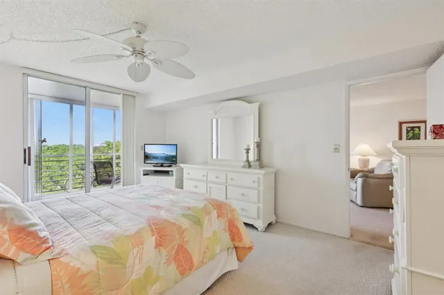a bedroom with a bed a chandelier and a flat tv screen
