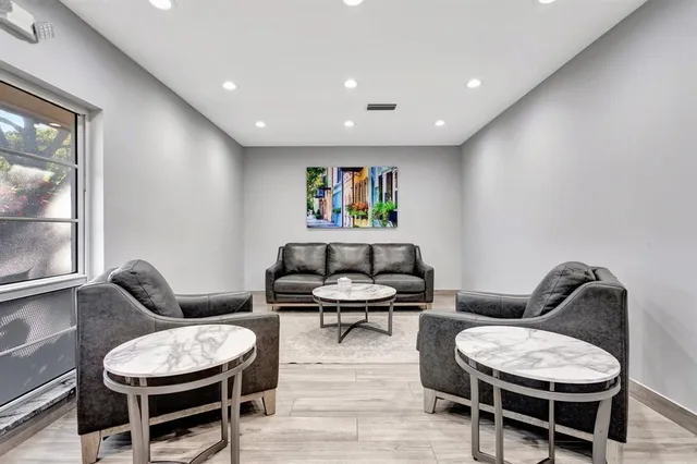 a kitchen with granite countertop a refrigerator oven a sink dishwasher and white cabinets with wooden floor