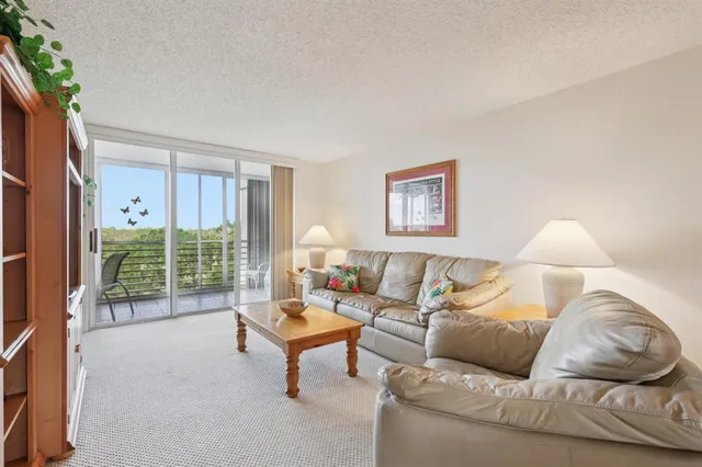 a living room with furniture and a large window with outer view