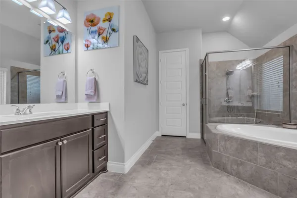 a bathroom with a sink a large mirror and a bathtub