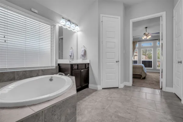 a spacious bathroom with a tub shower and mirror
