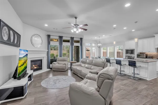 a living room with furniture a fireplace and a chandelier