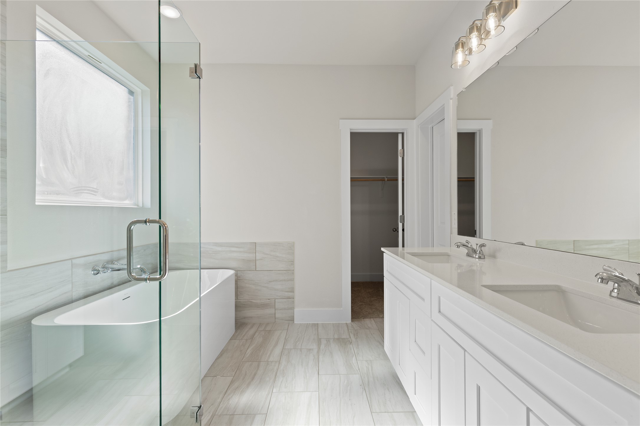 19705 Domino Champ Road Pflugerville, TX 78660 - Photo 24 of 38 An elegant soaking tub and dual vanity highlight this master bathroom with tile flooring.