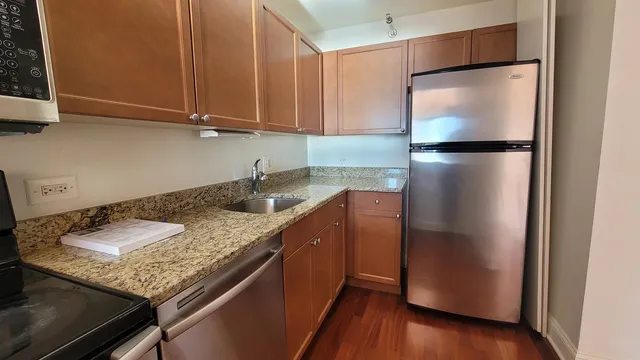 a kitchen with stainless steel appliances granite countertop a refrigerator and a cabinets