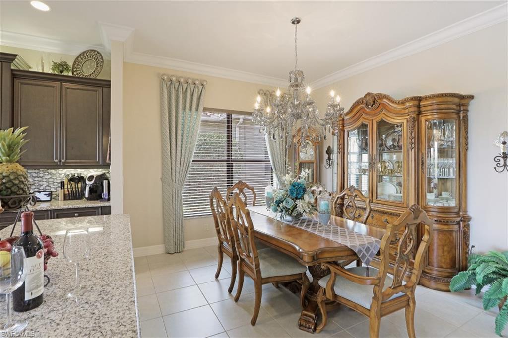 2832 Cinnamon Bay Circle Naples, FL 34119 - Photo 14 of 35 a view of a dining room with furniture and chandelier