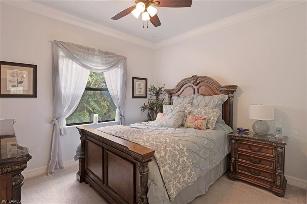 2832 Cinnamon Bay Circle Naples, FL 34119 - Photo 18 of 35 a bedroom with a bed and a chandelier