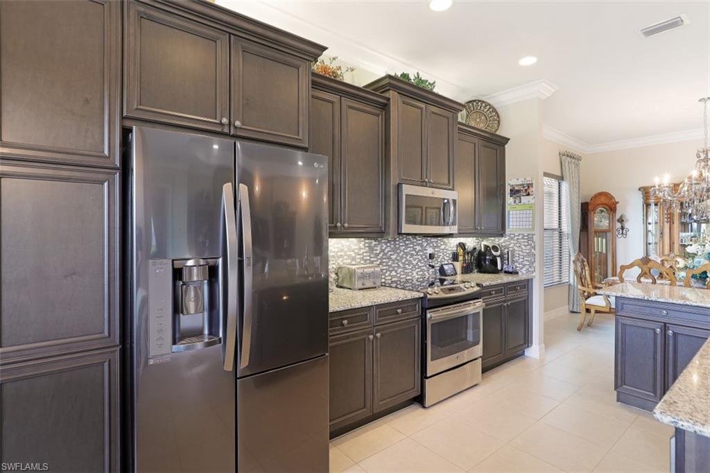 2832 Cinnamon Bay Circle Naples, FL 34119 - Photo 9 of 35 a kitchen with stainless steel appliances granite countertop a refrigerator and a sink