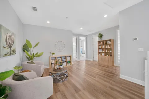 a living room with furniture and a wooden floor