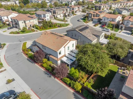 an aerial view of a house with a garden and mountain view in back