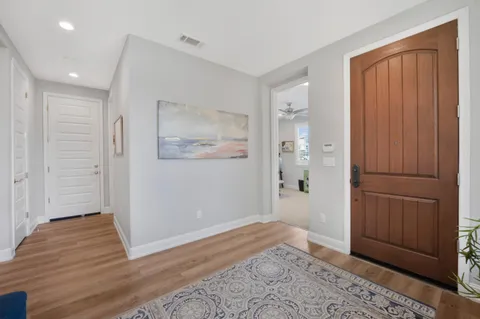 a view of a hallway with wooden floor and closet area