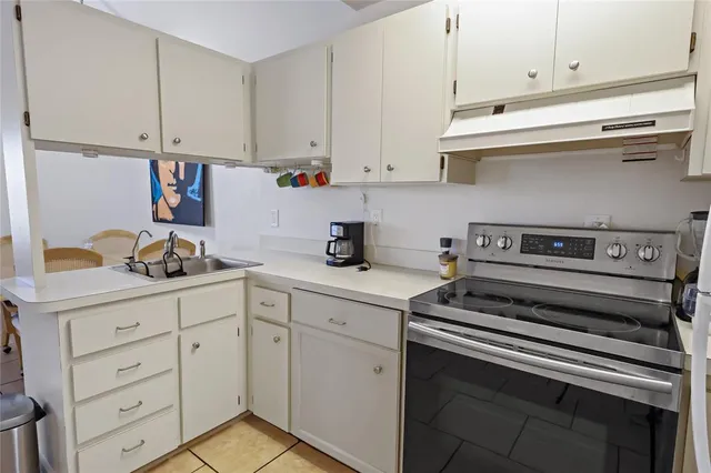 a kitchen with white cabinets and appliances