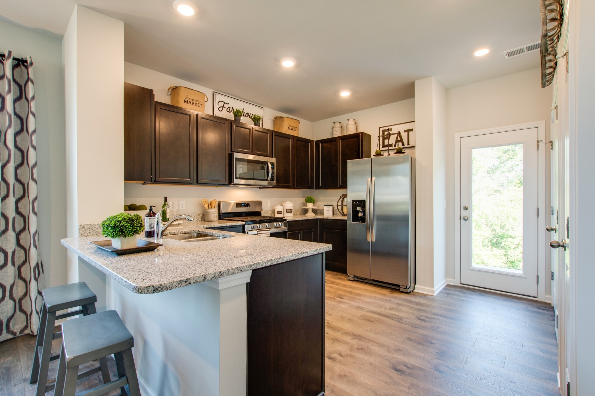 411 Waterfowl Way, Unit 119 Lebanon, TN 37090 - Photo 13 of 32 a kitchen with stainless steel appliances granite countertop a refrigerator a stove a sink and a microwave