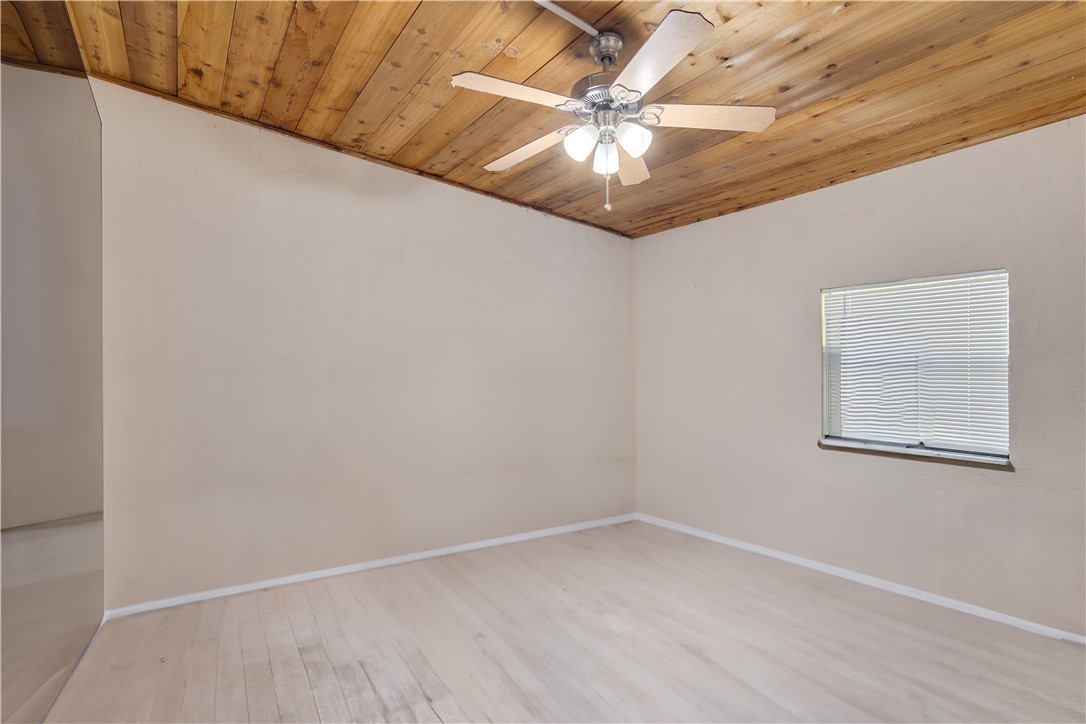 422 Del Monte Road Sebastian, FL 32958 - Photo 18 of 35 an empty room with a chandelier fan and wooden floor