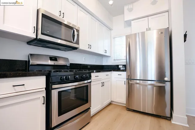 a kitchen with stainless steel appliances granite countertop a refrigerator microwave and sink