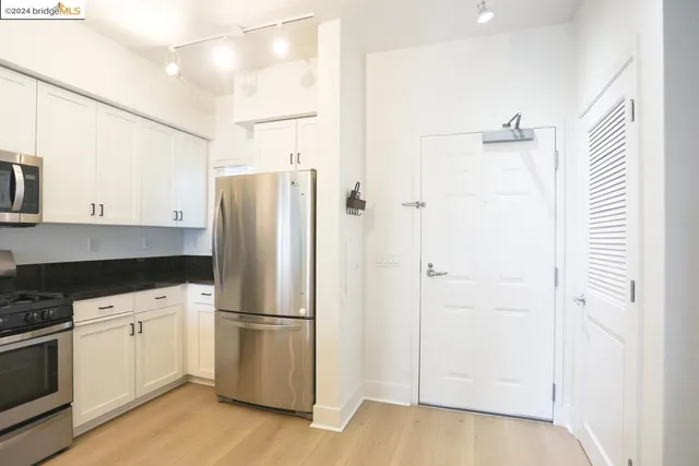 a kitchen with stainless steel appliances a refrigerator and a stove top oven